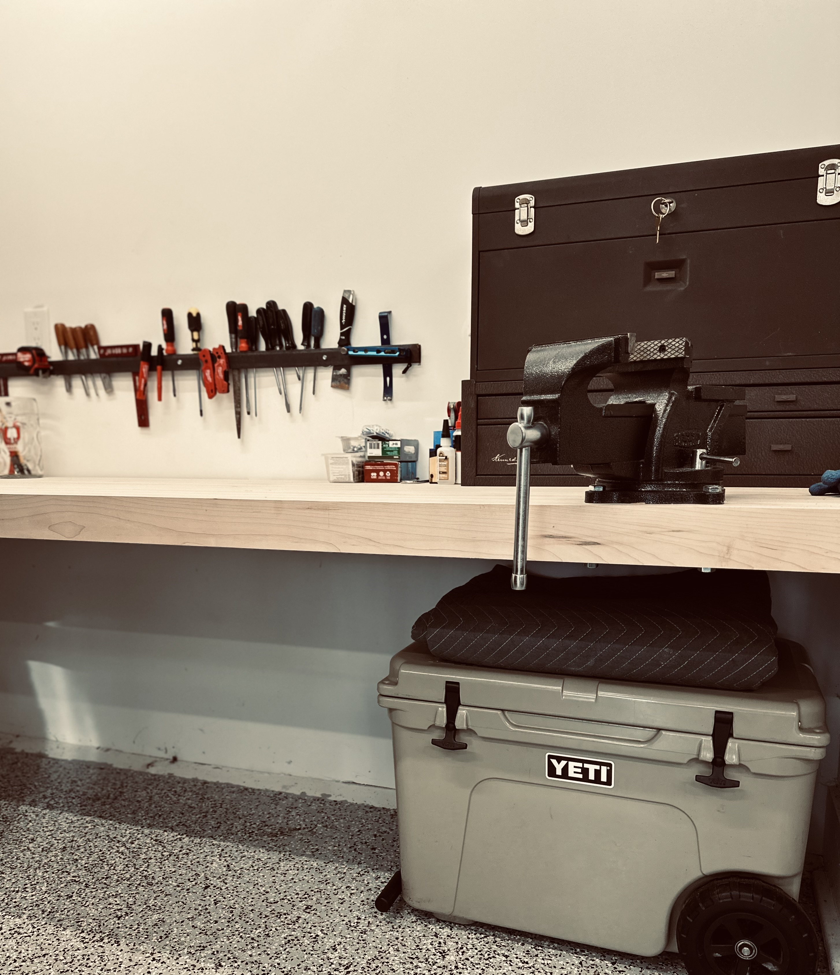 Ten-foot maple workbench with a bench vise, tool wall, and storage chest in the Locust Hill Customs shop